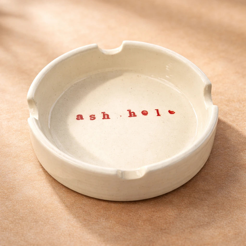 Quirky ceramic ashtray featuring fun message 'ash hole', perfect for coffee tables and balconies.